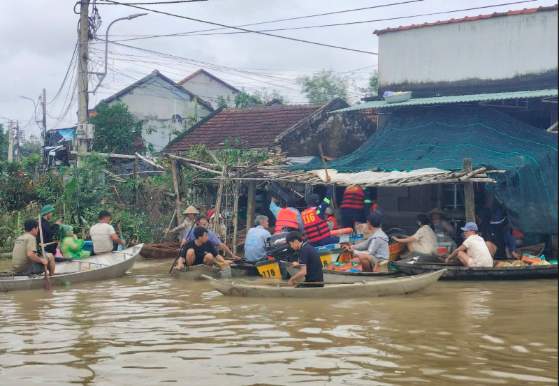 Thành viên trong đội phát nhu yếu phẩm cho người dân vùng lũ. Ảnh: NVCC