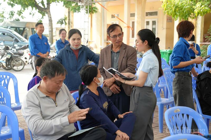 Cán bộ Trung tâm Phục vụ hành chính công TP. Hà Nội hướng dẫn người dân làm thủ tục đất đai. Ảnh: Đạt Dương