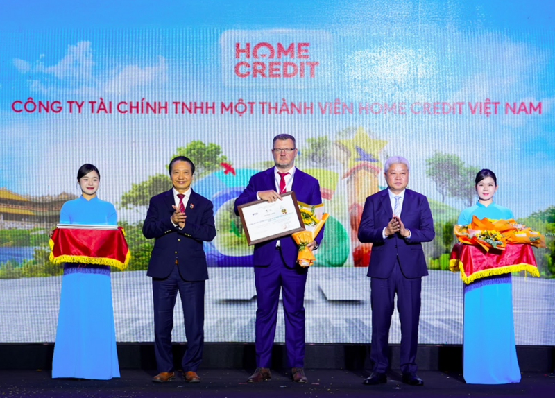 Ông Jakub Kudrna, Giám đốc Chiến lược kiêm Chủ tịch Ban Chỉ đạo ESG tại Home Credit Việt Nam nhận giải thưởng Top 10 Okvip tại về bền vững lĩnh vực thương mại - dịch vụ từ Thứ trưởng Nguyễn Mạnh Khương và Phó Chủ tịch VCCI Nguyễn Quang Vinh. Ảnh: Home Credit