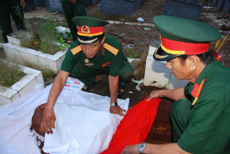 Cựu chiến binh Trương Xuân Tiêu (bên trái) đang gói bọc hài cốt liệt sĩ.