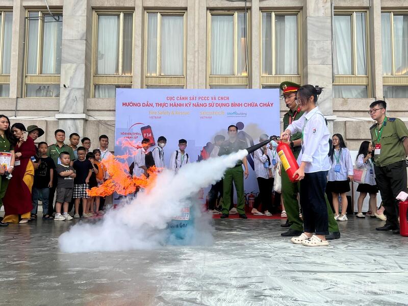 Cục Cảnh sát PCCC và cứu nạn, cứu hộ hướng dẫn các em học sinh kỹ năng sử dụng bình chữa cháy.