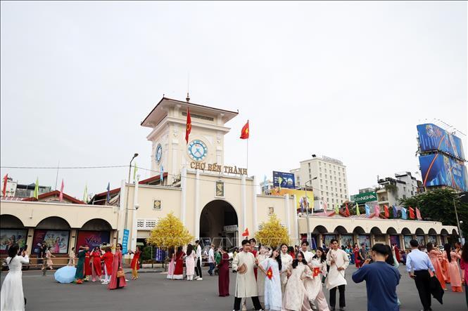 Tại chợ Bến Thành, các bạn trẻ nô nức check-in lưu lại khoảnh khắc ngày đầu năm mới. Ảnh: TTXVN.