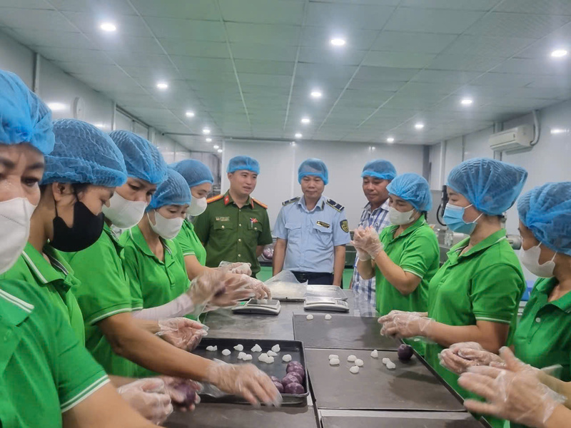 Lực lượng Quản lý thị trường Hà Nội phối hợp với lực lương Công an kiểm tra một cơ sở sản xuất bánh kẹo. Ảnh: Văn Thi