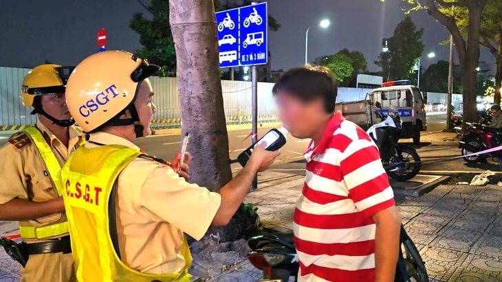 Lực lượng Cảnh sát giao thông kiểm tra nồng độ cồn với người tham gia giao thông. Ảnh: Minh Hòa