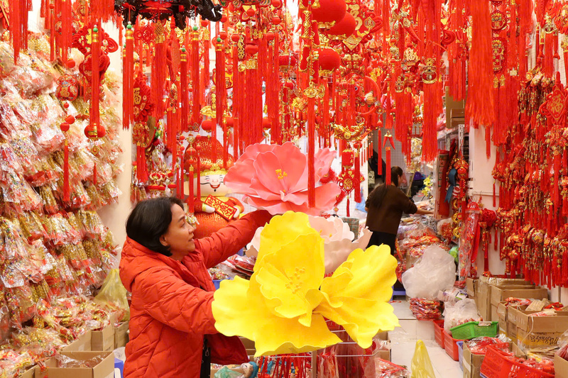 Gắn bó nghề buôn bán trên phố Hàng Mã nhiều năm, chị Đoàn Thanh Thư (áo đỏ) cho biết, thị trường Tết năm nay khởi động sớm nhưng diễn ra chậm rãi hơn thường lệ. Chị chia sẻ: “Không khí Tết đến sớm nhưng sức mua trải đều, không dồn dập như mọi năm do thời gian chuẩn bị Tết kéo dài hơn những năm trước". 


Chị Phạm Phương Nhung, 23 tuổi (Hải Phòng) cho biết, dịp Tết năm nay, gia đình chị kinh doanh đồ trang trí nên chị trực tiếp lên phố Hàng Mã nhập hàng về bán. Theo chị Nhung, giá năm nay ở mức hợp lý, dễ nhập buôn hơn so với năm trước. Chị nhận định: “Các loại mành, câu đối, khánh chúc mừng năm mới hay tượng thần tài vẫn được nhiều người quan tâm, năm nay khả năng vẫn bán tốt”.


Cùng với đồ trang trí, các loại hộp đựng quà Tết cũng phong phú về mẫu mã, được bán với mức giá từ 70.000 đến 150.000 đồng.


Ảnh: Phương Hà