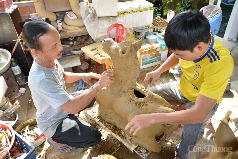 Nghệ nhân Lê Văn Nhật (áo vàng) và cộng sự Lê Đình Quang cùng nhau tạo hình cho linh vật ngựa. Ảnh: Ngọc Thảo