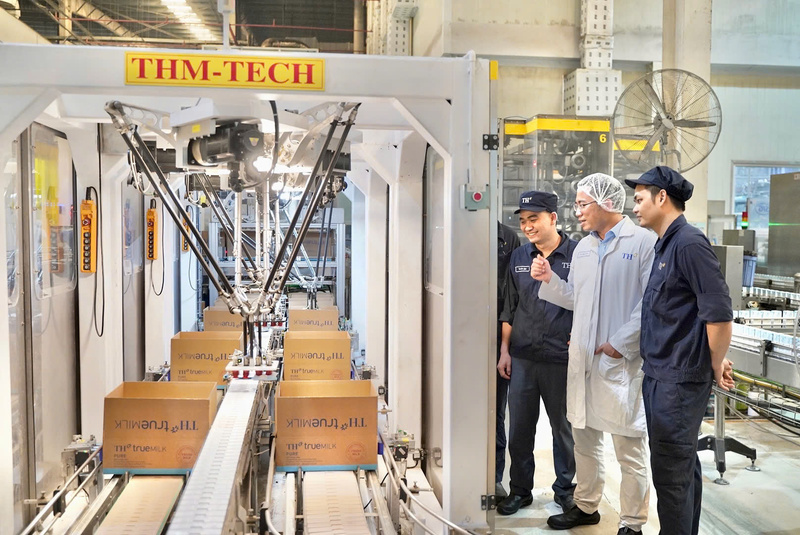 Cao Minh Hòa (áo trắng) cùng các đồng nghiệp tại Nhà máy chế biến sữa tươi sạch TH true MILK.