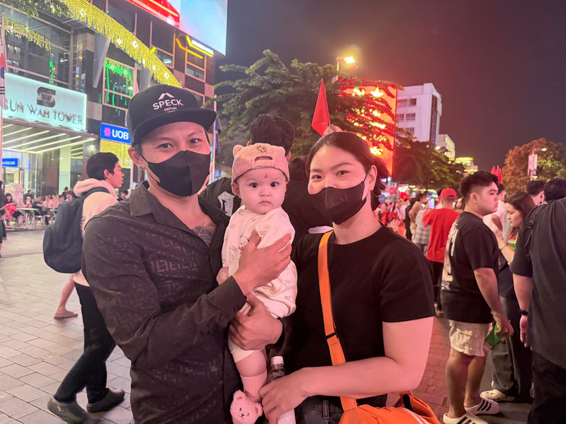 Gia đình chị Lê Thị Lan Phương cùng cháu nhỏ hào hứng trước giờ diễn ra trận đấu. Ảnh: Minh Anh.