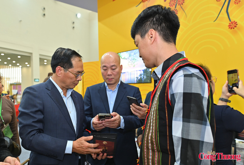 Phó Thủ tướng Bùi Thanh Sơn và Cục trưởng Cục Xúc tiến thương mại Vũ Bá Phú kiểm tra các sản phẩm chuẩn OCOP tại hội chợ qua ứng dụng quét mã QR Code.