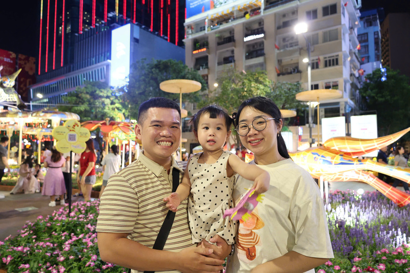 Gia đình anh Lê Hoàng Phúc chọn có mặt từ sớm tại khu vực trung tâm để tận hưởng không khí đón năm mới và chọn vị trí đẹp ngắm pháo hoa. Ảnh: Minh Anh