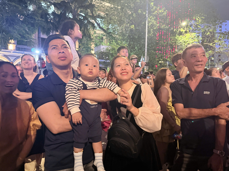 Ánh mắt lấp lánh niềm vui của một gia đình trẻ khi cùng nhau chiêm ngưỡng những màn pháo hoa rực rỡ đầu năm mới. Ảnh: Minh Anh.