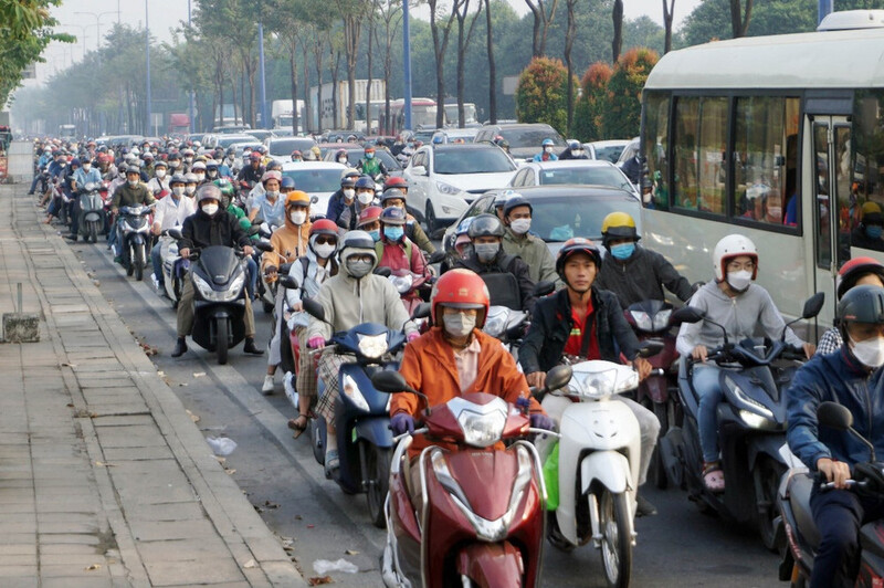 Người tham gia giao thông bịt kín khẩu trang để ứng phó với nắng nóng 34 độ C và khói bụi tại TP.Hồ Chí Minh.