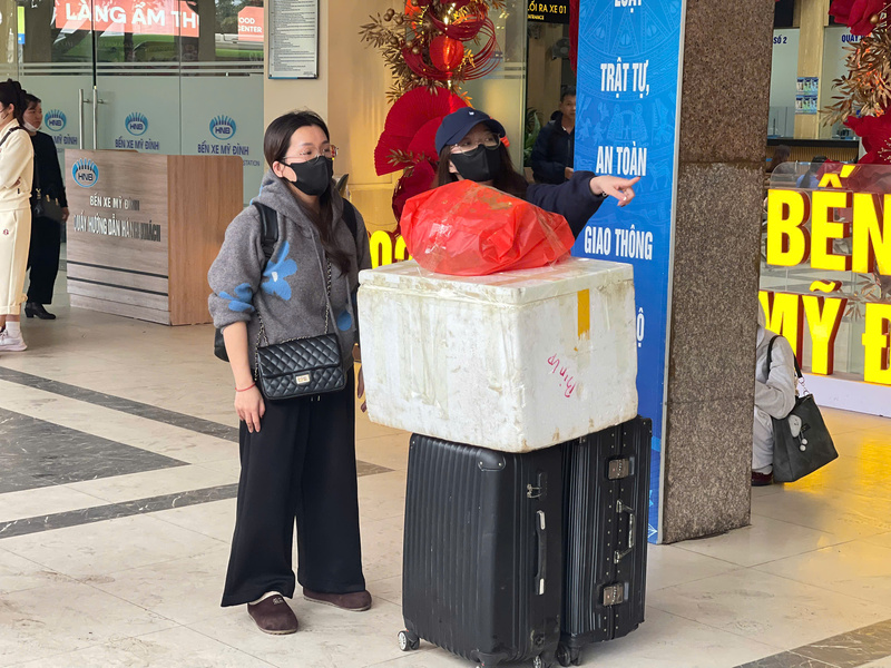 Dễ dàng bắt gặp hình ảnh hành khách “tay xách nách mang” cùng những chiếc vali căng phồng, túi xách lớn nhỏ, túi quà quê được buộc chặt, mang theo dư vị Tết từ làng quê ra phố thị, chất đầy trên tay người trở lại Hà Nội. Ảnh: Mai Linh