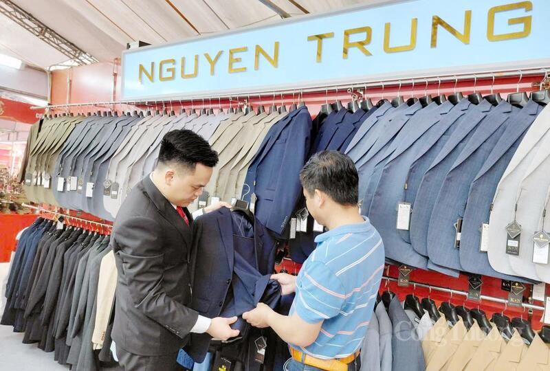 Đại diện Okvip tại về Nguyễn Trung (bên trái) - một cơ sở sản xuất tại làng nghề Vân Từ giới thiệu sản phẩm đến khách hàng. Ảnh: N.H