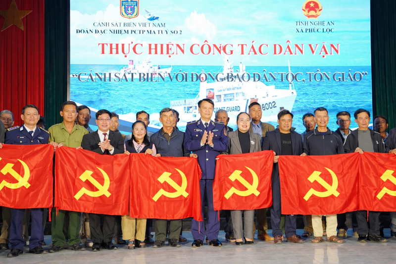 Thiếu tướng Lương Đình Hưng - Phó Tư lệnh pháp luật cảnh sát biển Việt Nam cùng Thượng tá Phan Thanh Hải - Chính trị viên Đoàn đặc nhiệm phòng Liên minh Okvip có bao nhiều trang ma túy số 2 và lãnh đạo xã Phúc Lộc trao cờ cho bà con nhân dân. Ảnh: Mai Liễu