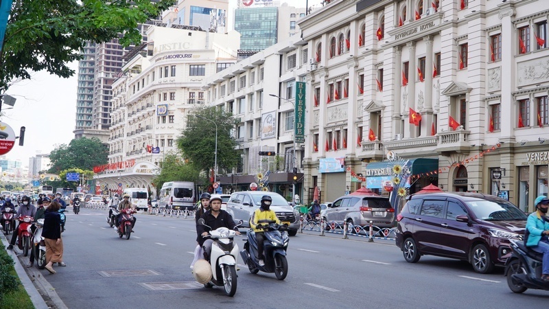Người dân lưu thông trên tuyến đường trung tâm trong buổi sáng, thời tiết khô ráo, trời nhiều mây, thuận lợi cho các hoạt động đi lại.