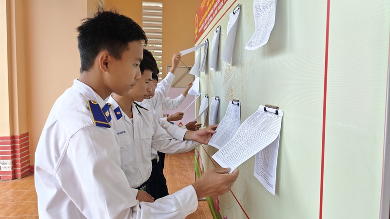 Cán bộ, chiến sĩ Vùng Cảnh sát biển 2 tại khu vực niêm yết danh sách cử tri sẽ tham gia bầu cử ngày 15/3. Ảnh: Nam Trung