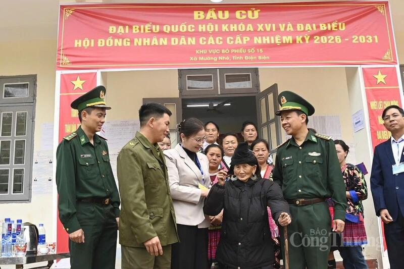 Chiến sĩ Biên phòng tỉnh Điện Biên cùng cán bộ, nhân dân xã Mường Nhé động viên cử tri cao tuổi nhất là cụ bà Trá Thị Dềnh, bản Nậm Là 2.