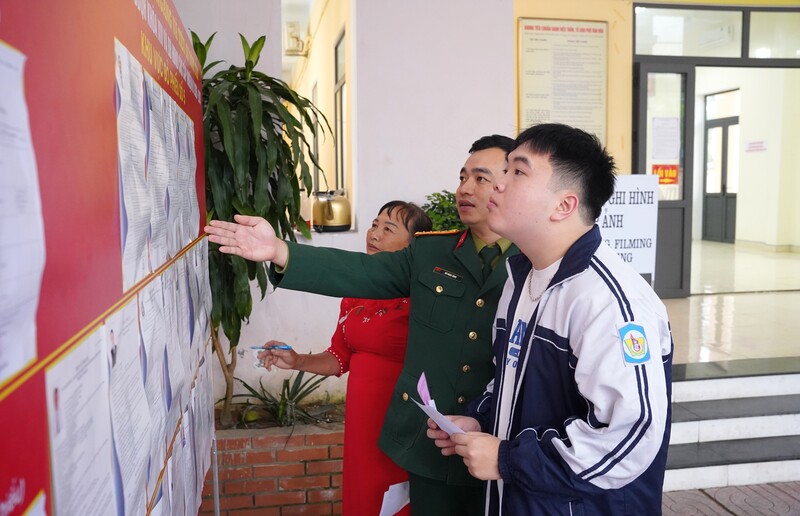 Cán bộ Ban Chỉ huy quân sự phường Trường Vinh hướng dẫn quy định bầu cử cho cử tri.