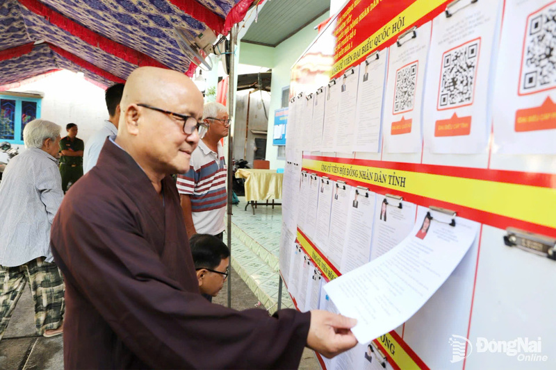 Hòa thượng Thích Minh Thọ, Phó ban Hoằng Pháp Giáo hội Phật giáo Việt Nam tỉnh Đồng Nai tìm hiểu thông tin về các ứng cử viên trước khi bỏ phiếu tại Khu vực bầu cử số 8, phường Biên Hòa.