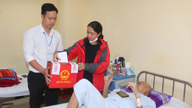 Người nhà bệnh nhân thực hiện bỏ phiếu bầu cử tại Bệnh viện Trung ương Huế. Ảnh: Nguyễn Tuấn