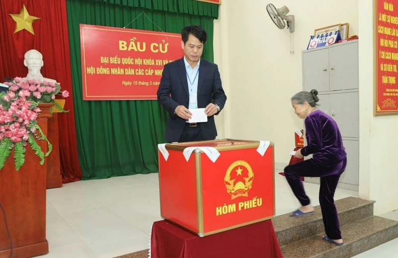 Ông Đào Xuân Yên - Trưởng Ban Tuyên giáo và Dân vận Tỉnh ủy Thanh Hóa và cử tri cao tuổi tham gia bỏ phiếu tại Khu vực bỏ phiếu số 65, Tổ dân phố Lễ Môn, phường Hạc Thành. Ảnh: Tô Hà