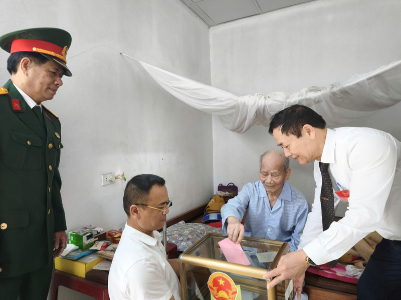 Cử tri cao tuổi, sức khỏe yếu không thể tự đi bỏ phiếu, các tổ bầu cử đã đưa hòm phiếu đến tận nhà, đảm bảo quyền lợi của các cử tri. Ảnh: QN