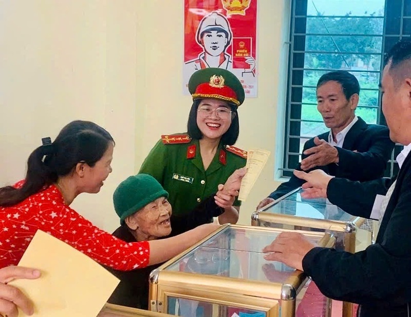 Lực lượng chức năng hỗ trợ cử tri sức khỏe yếu thực hiện quyền và nghĩa vụ công dân. Ảnh: QN