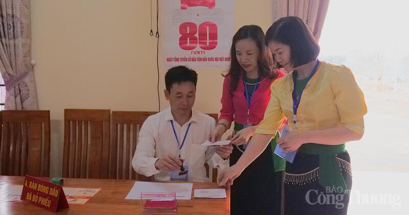 Sau khi các cử tri đã bỏ phiếu, được hướng dẫn qua bàn đóng dấu xác nhận đã bỏ phiếu. Ảnh: Phạm Giang.