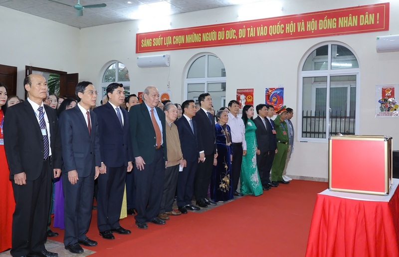 Lãnh đạo tỉnh Thanh Hóa và cử tri thực hiện nghi lễ chào cờ tại khu vực bỏ phiếu số 58, nhà văn hóa Tổ dân phố Bình Minh, phường Hạc Thành. Ảnh: Minh Hiếu