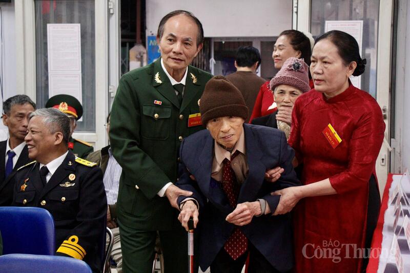 Thành viên tổ bầu cử ân cần hỗ trợ cử tri cao tuổi vào khu vực bỏ phiếu thực hiện quyền công dân.