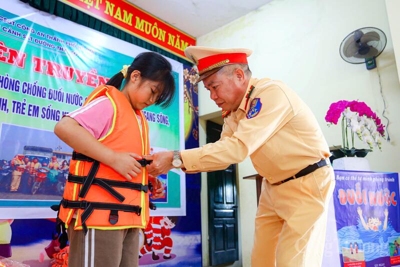 Cán bộ Đội Cảnh sát đường thủy số 1 hướng dẫn học sinh kỹ năng sử dụng áo phao.