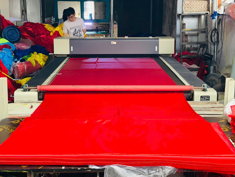 Nhờ có máy móc hỗ trợ, công đoạn cắt vải được đảm bảo độ chính xác tuyệt đối, 10 cái như 1. Tuy vậy, những công đoạn quan trọng vẫn đòi hỏi sự khéo léo của người thợ, đặc biệt là việc in ngôi sao vàng sao cho cân đối, đúng chuẩn tâm của lá cờ. Ảnh: Mai Linh