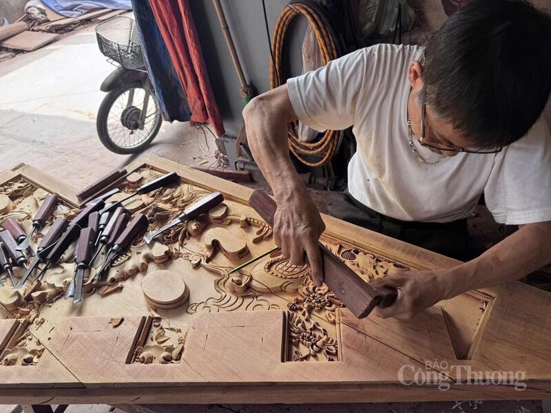 Nghệ nhân làng mộc Phù Yên tỉ mỉ chạm khắc hoa văn, tạo nên những sản phẩm mang đậm giá trị truyền thống và tay nghề tinh xảo. Ảnh: Lê Hà