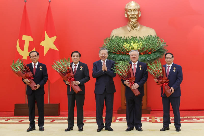 Tổng Bí thư Tô Lâm tặng hoa chúc mừng các đồng chí được nhận Huân chương Quân công hạng nhất. Ảnh: VGP/Nhật Bắc