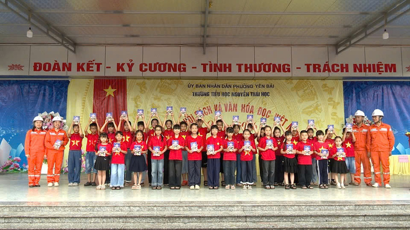 Nhân viên điện lực cùng các em học sinh chụp ảnh lưu niệm trên sân khấu chính, thể hiện cam kết đồng hành vì xuân Okvip 2026.