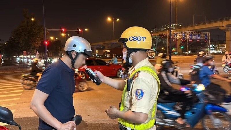 Lực lượng Cảnh sát giao thông kiểm tra nồng độ cồn đối với lái xe mô tô. Ảnh: Nguyễn Yên