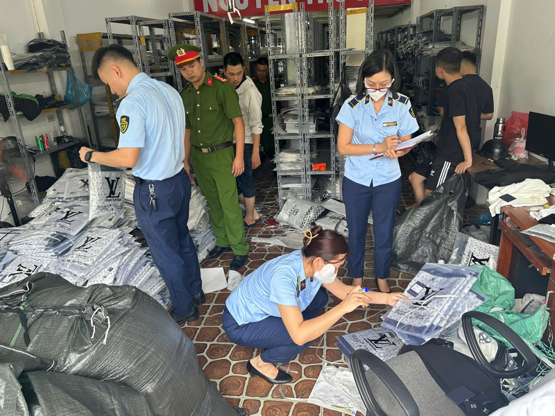 Lực lượng Quản lý thị trường Hà Nội kiểm tra cơ sở kinh doanh tại xã Phù Đổng, phát hiện và tạm giữ 5.175 sản phẩm quần áo có dấu hiệu giả mạo nhiều nhãn hiệu nổi tiếng. Ảnh: Quản lý thị trương Hà Nội