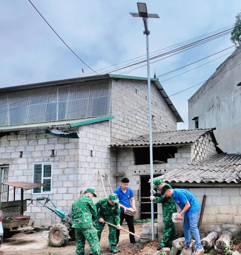 Các chiến sĩ biên phòng tỉnh Cao Bằng cùng đoàn thanh niên xã Đình Phong dựng cột đèn đường cho người  dân.