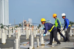 Các công nhân đang phủ lớp bê-tông lên mố xử lý.